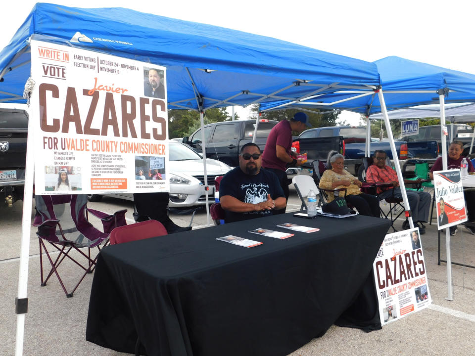 Javier Cazares, a write-in candidate for county commissioner, sits in his campaign booth outside of the town's largest early voting location on Monday, Oct. 24, 2022, in Uvalde, Texas. The Uvalde school massacre has cast a long shadow in the midterm elections in Texas, intensifying Republican Gov. Greg Abbott’s reelection fight against Democrat Beto O’Rourke and driving a blitz of television ads. (AP Photo/Acacia Coronado)