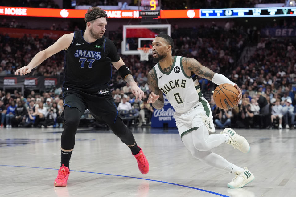 Milwaukee Bucks guard Damian Lillard (0) drives against Dallas Mavericks guard Luka Doncic (77) during the first half of an NBA basketball game in Dallas, Saturday, Feb. 3, 2024. (AP Photo/LM Otero)