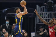 Golden State Warriors guard Stephen Curry, left, shoots a 3-point basket over Houston Rockets forward Tari Eason (17) during the first half of an NBA basketball game in San Francisco, Saturday, Dec. 3, 2022. (AP Photo/Godofredo A. Vásquez)