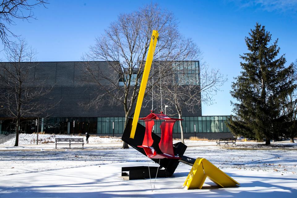 A person walks past sculptures outside the Stanley Museum of Art on the University of Iowa campus.