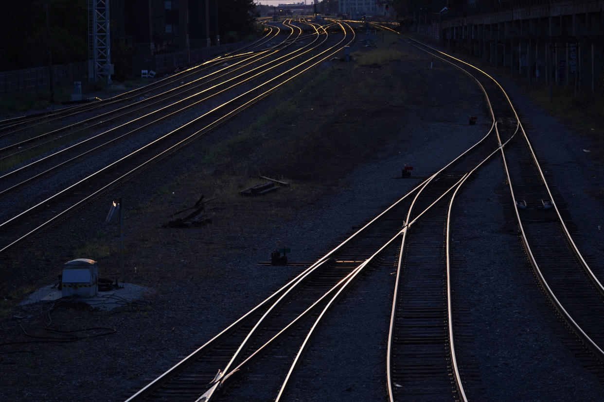 FILE - Train tracks headed west reflect the sun setting near Chicago's Union Station, Sept. 14, 2022. The Biden administration is saying the U.S. economy would face a severe economic shock if senators don't pass legislation this week to avert a rail worker strike. The administration is delivering that message personally to Democratic senators in a closed-door session Thursday, Dec. 1. (AP Photo/Charles Rex Arbogast, File)