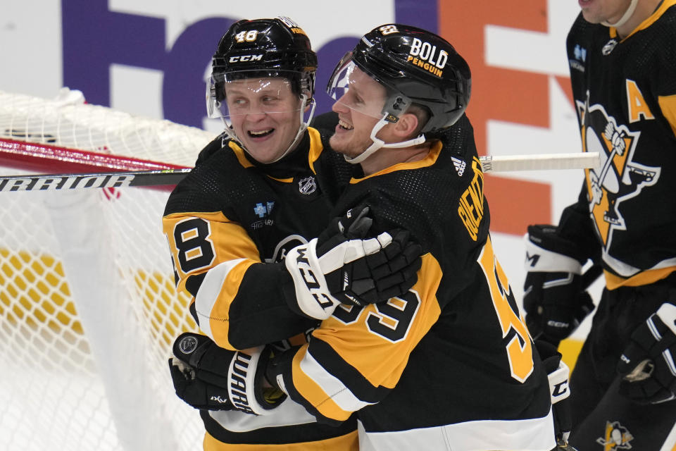 Pittsburgh Penguins' Jake Guentzel (59) celebrates his goal with Valtteri Puustinen (48) during the first period of an NHL hockey game against the Arizona Coyotes in Pittsburgh, Tuesday, Dec. 12, 2023. (AP Photo/Gene J. Puskar)