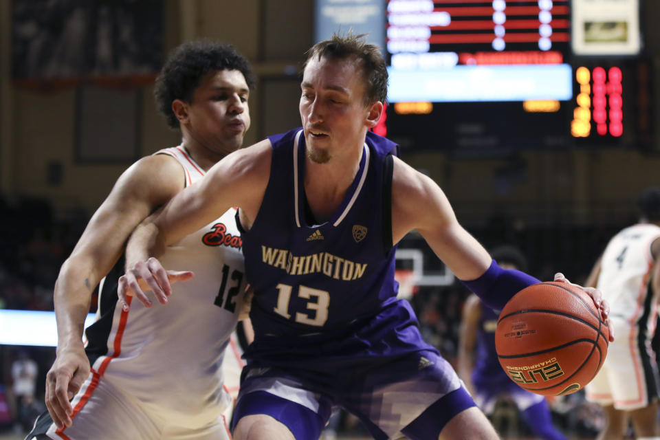 Washington forward Moses Wood (13) drives to the basket as Oregon State forward Michael Rataj (12) defends during the second half of an NCAA college basketball game Saturday, Feb. 10, 2024, in Corvallis, Ore. (AP Photo/Amanda Loman)