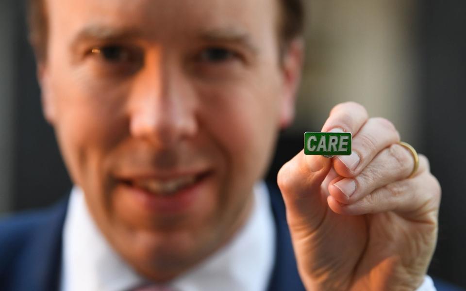  Health Secretary Matt Hancock showing the new 'Care' badge, described as a "badge of honour" for social care workers so they can get the same public recognition as NHS staff - PA