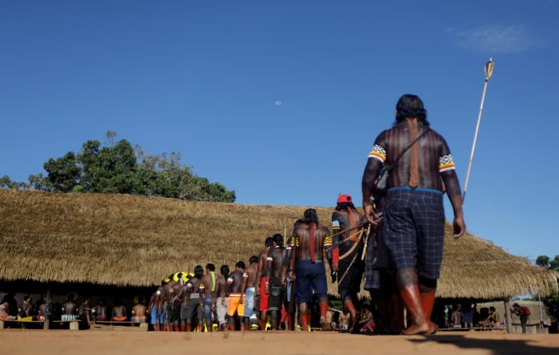 Indigenous people of Kayapo tribe, get inside the Casa dos Homens (Men House) to attend a meeting during a four-day pow wow in Piaracu village, in Xingu Indigenous Park, near Sao Jose do Xingu, Mato Grosso state