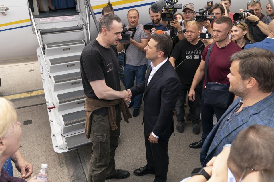 FILE - In this file photo taken on Saturday, Sept. 7, 2019, Ukraine's President Volodymyr Zelenskiy, right, greets Ukrainian prisoner filmmaker Oleg Sentsov upon his arrival at Boryspil airport, outside Kyiv, Ukraine. Barely 100 days into his tenure Ukrainian President Volodymyr Zelenskiy finds himself in an unexpected position - having to strike a balancing act with Ukraine's staunch ally, the United States. (Ukrainian Presidential Press Office via AP, File)