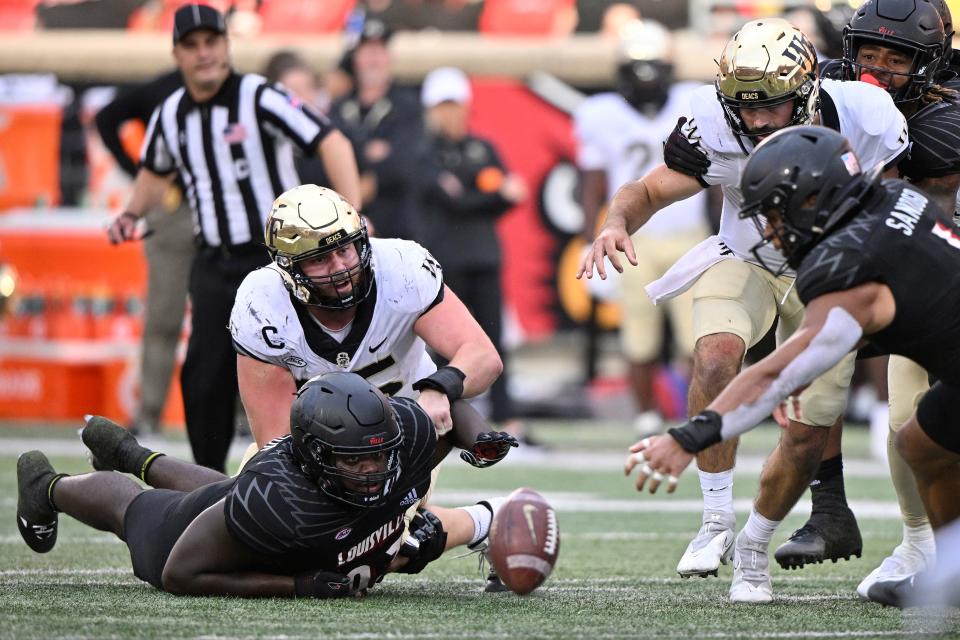 Louisville defensive lineman Jared Dawson (93) scrambles to recover the ball after forcing a Wake Forest fumble during an October 2022 game.