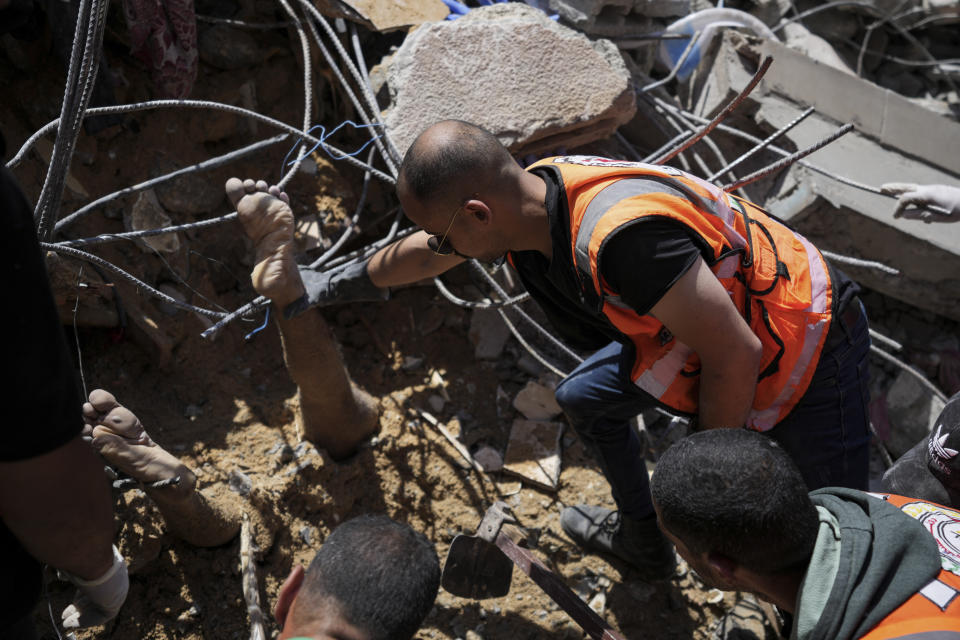 Palestinians rescuers dig around the body of man in the rubble of a building destroyed in an Israeli airstrike in Nuseirat, Gaza Strip, Tuesday, May 14, 2024. (AP Photo/Abdel Kareem Hana)
