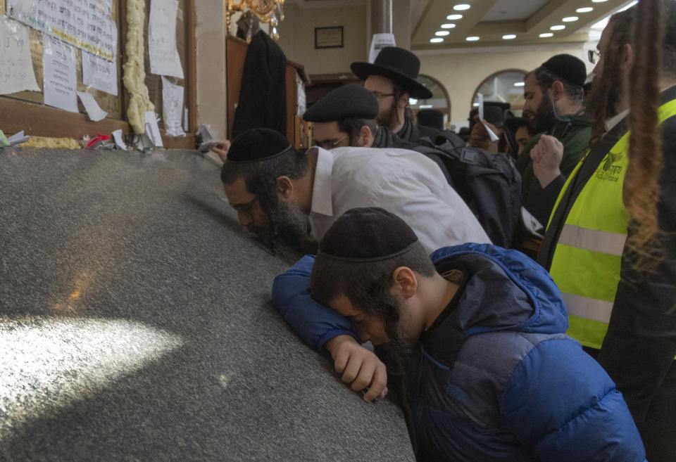 An Orthodox Jew prays at the gravestone of Rabbi Nachman, the great grandson of the founder of Hasidic movement, in the town of Uman, 200 kilometers (125 miles) south of Ukraine's capital Kiev, Ukraine, Sunday, Sept. 25, 2022. Thousands of Hasidic Jewish pilgrims flocked to central Ukraine to mark the Jewish new year Sunday, ignoring international travel warnings as Russia struck more targets from the air and mobilized its citizens to stem losses in the war that has entered its eighth month. (AP Photo/Efrem Lukatsky)