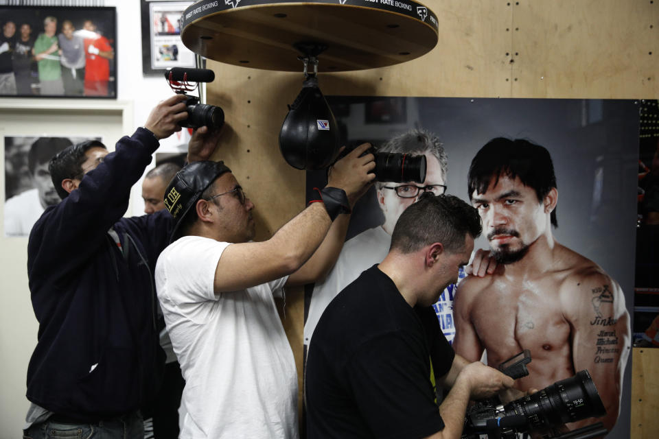 Film production crew members record as boxer Manny Pacquiao, not pictured, hits a speed bag at the Wild Card Boxing Club Monday, Jan. 14, 2019, in Los Angeles. The Filipino legend is in the winter of his career, gearing up for what could be one big last fight. Saturday's bout versus Broner isn't it, but Pacquiao trains with the knowledge that a second megafight against Floyd Mayweather could possibly be just months away if all goes well. (AP Photo/Jae C. Hong)