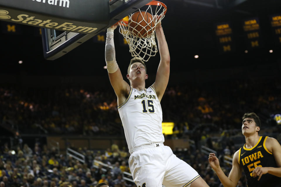 Michigan center Jon Teske (15) dunks against Iowa center Luka Garza (55) in the first half of an NCAA college basketball game in Ann Arbor, Mich., Friday, Dec. 6, 2019. (AP Photo/Paul Sancya)