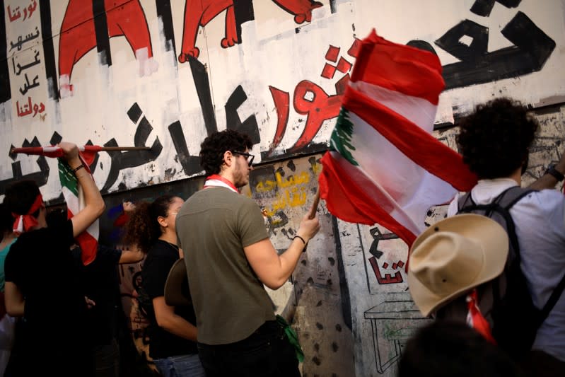 Protesters hit the fencing of a wrecked building at a demonstration organised by students during ongoing anti-government protests in Beirut