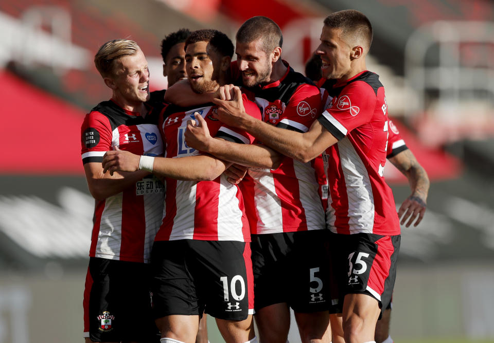 Southampton's Che Adams, second left, is congratulated by teammates after scoring his team's first goal during the English Premier League soccer match between Southampton and Manchester City at St. Mary's Stadium in Southampton, England, Sunday, July 5, 2020. (AP Photo/Frank Augstein,Pool)