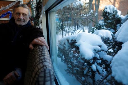 Tom Smith, who is homeless, sits for a portrait inside the Pine Street Inn, with snow covering the bushes outside, in Boston, Massachusetts, U.S., January 5, 2018. REUTERS/Brian Snyder