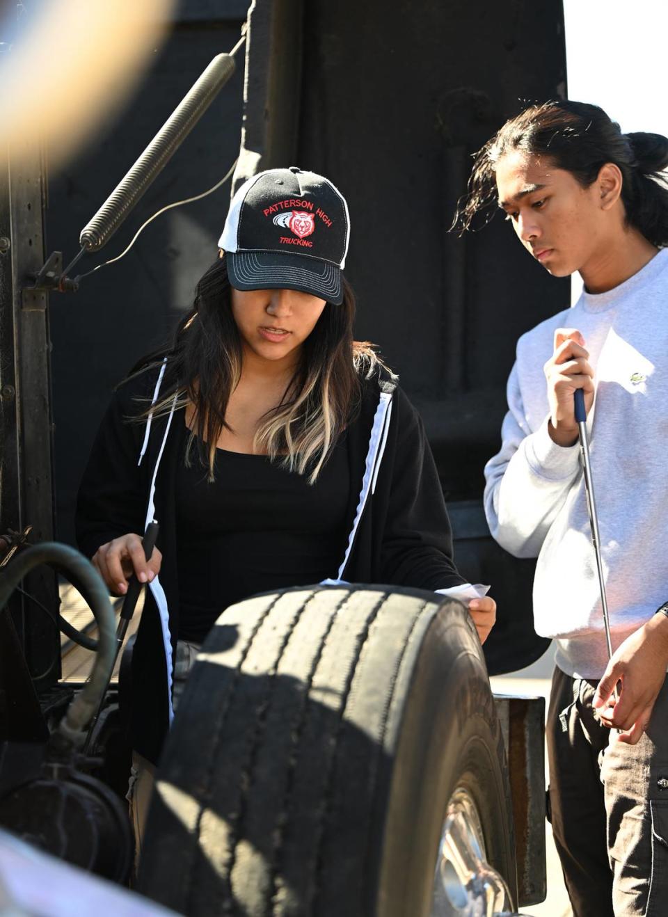 Students Teffany Dominguez Santamaria, left, and Melvino Roxas conduct a pre-trip inspection during trucking class at Patterson High School in Patterson, Calif., Friday, Oct. 27, 2023. The school has career technical education class to teach trucking and help students gain a commercial drivers permit.