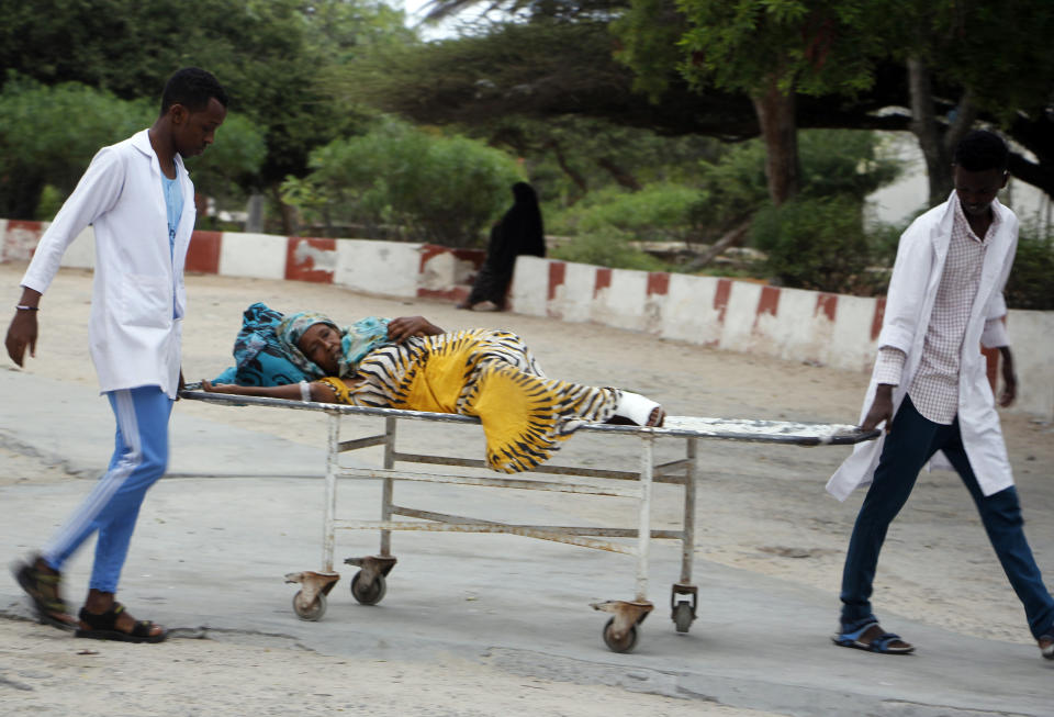 Medical workers help civilian on stretcher who was wounded in suicide bomb, at Madina hospital, Mogadishu, Wednesday, July 24, 2019. A suicide bomber walked into the office of Mogadishu's mayor and detonated explosives strapped to his waist, killing several people and badly wounding the mayor, Somali police said Wednesday. (AP Photo/Farah Abdi Warsameh)