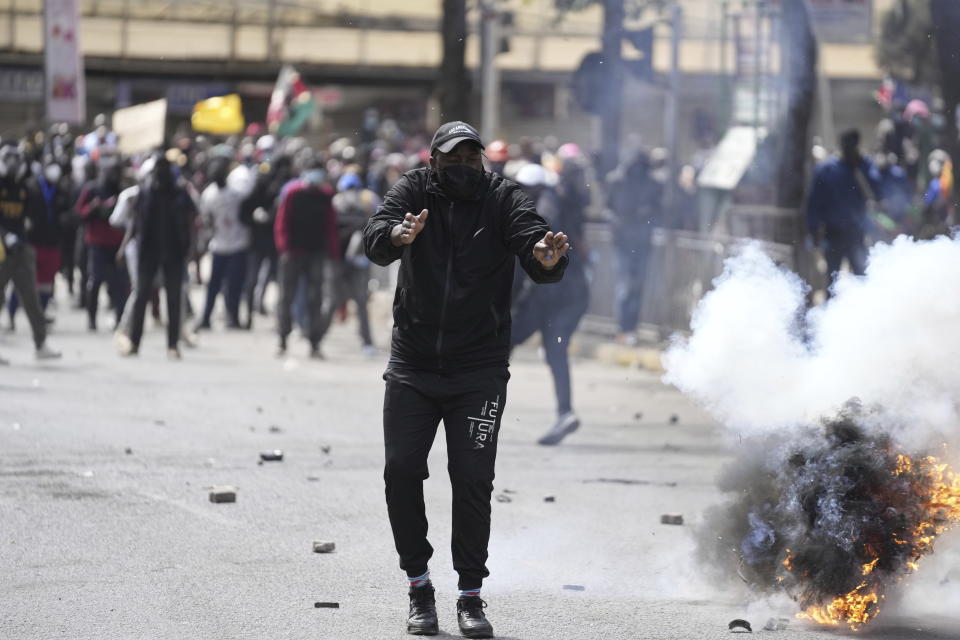 Protesters scatter as police fire tear gas at them during a protest over proposed tax hikes in a finance bill in downtown Nairobi, Kenya Tuesday, June. 25, 2024. (AP Photo/Brian Inganga)