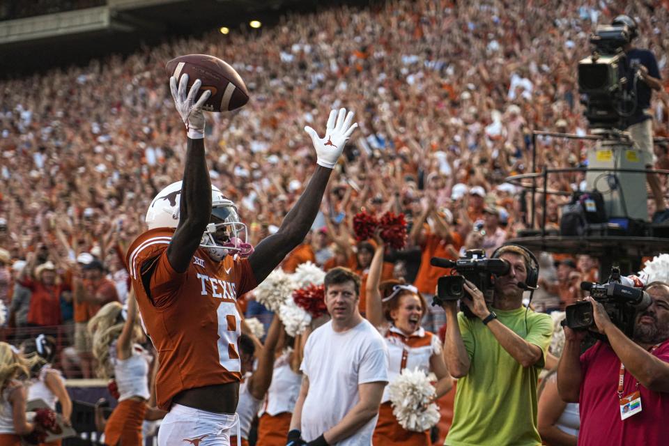 Texas wide receiver Xavier Worthy celebrates his touchdown catch in the first quarter that led off the scoring in the Longhorns' 38-20 win over West Virginia. He would go on to add a second touchdown catch as well as a touchdown throw.