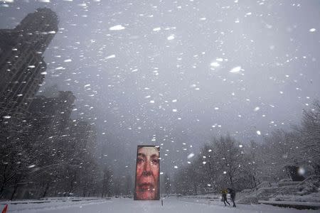 Two men walk past the Crown Fountain in blizzard conditions in Chicago, Illinois February 1, 2015. REUTERS/Jim Young