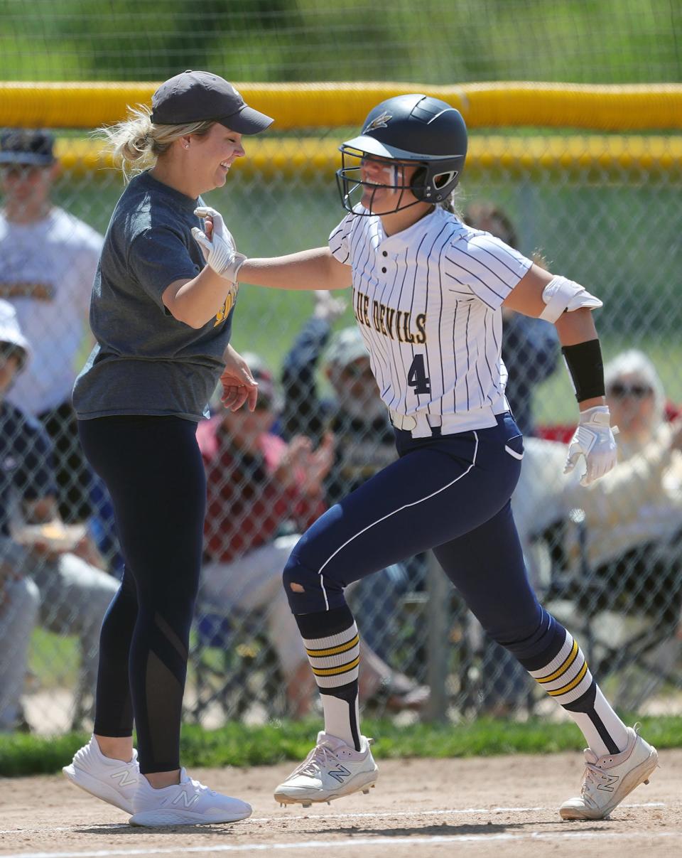 Tallmadge softball coach Brittany Lightel, left, high fives third baseman Zoe Rensel as she rounds third after hitting a solo home run against Copley during the fourth inning of a Division II district semifinal softball game in Canton on Tuesday.