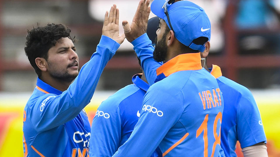 Kuldeep Yadav and Virat Kohli celebrate the wicket of Chris Gayle in their ODI clash. (Photo by RANDY BROOKS/AFP/Getty Images)