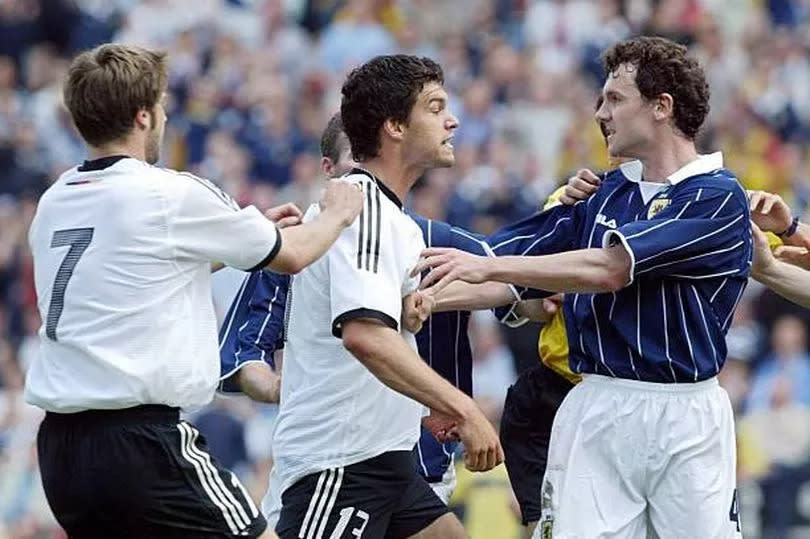 Michael Ballack and Christian Dailly square up in a fierce battle between Scotland and Germany