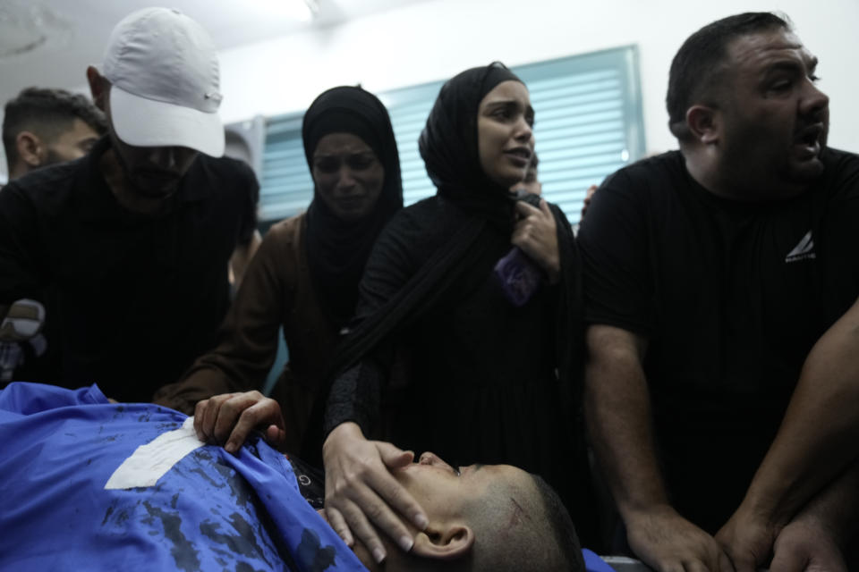 Relatives mourn Palestinian boy Ali Abu Khazna, who was killed during an Israeli army raid on Nur Shams refugee camp, in a morgue in Tulkarem, West Bank, Thursday, Oct. 19, 2023. (AP Photo/Majdi Mohammed)
