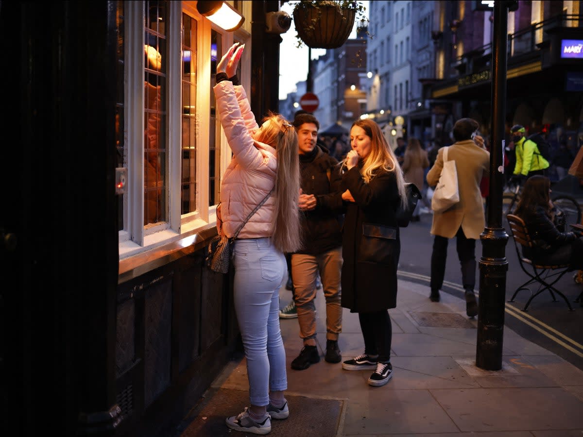 File image: A customer warms her hands on a pavement heater outside a pub  (AFP via Getty Images)