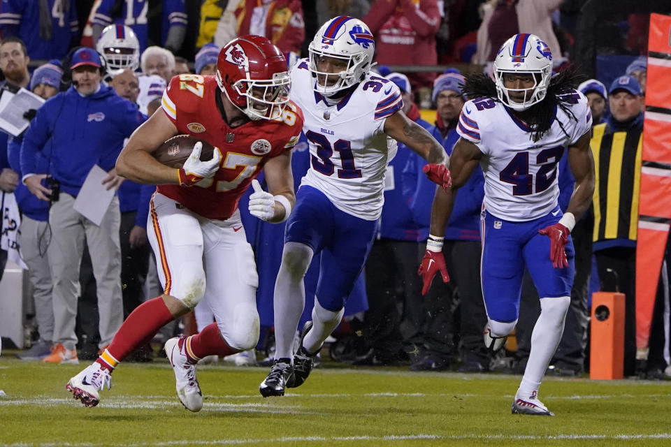 Kansas City Chiefs tight end Travis Kelce (87) runs with the ball as Buffalo Bills cornerback Rasul Douglas (31) and linebacker Dorian Williams (42) defend during the second half of an NFL football game Sunday, Dec. 10, 2023, in Kansas City, Mo. (AP Photo/Ed Zurga)