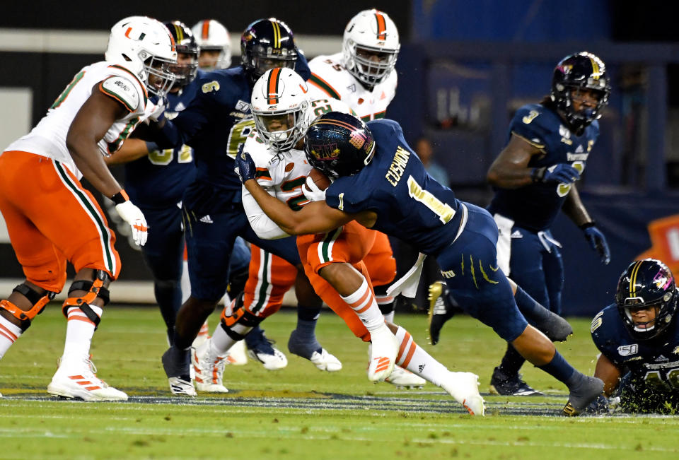 Miami Hurricanes running back Cam'Ron Harris (23) is tackled by FIU Golden Panthers defensive back Olin Cushion (1) during the first half. (USA Today)