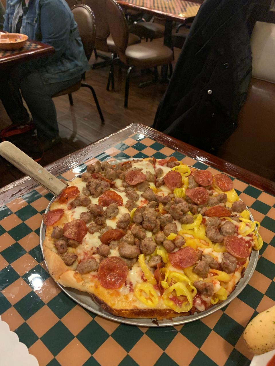 A sausage and pepperoni pizza with banana peppers is served at Angie's Italian Restaurant in Barberton.