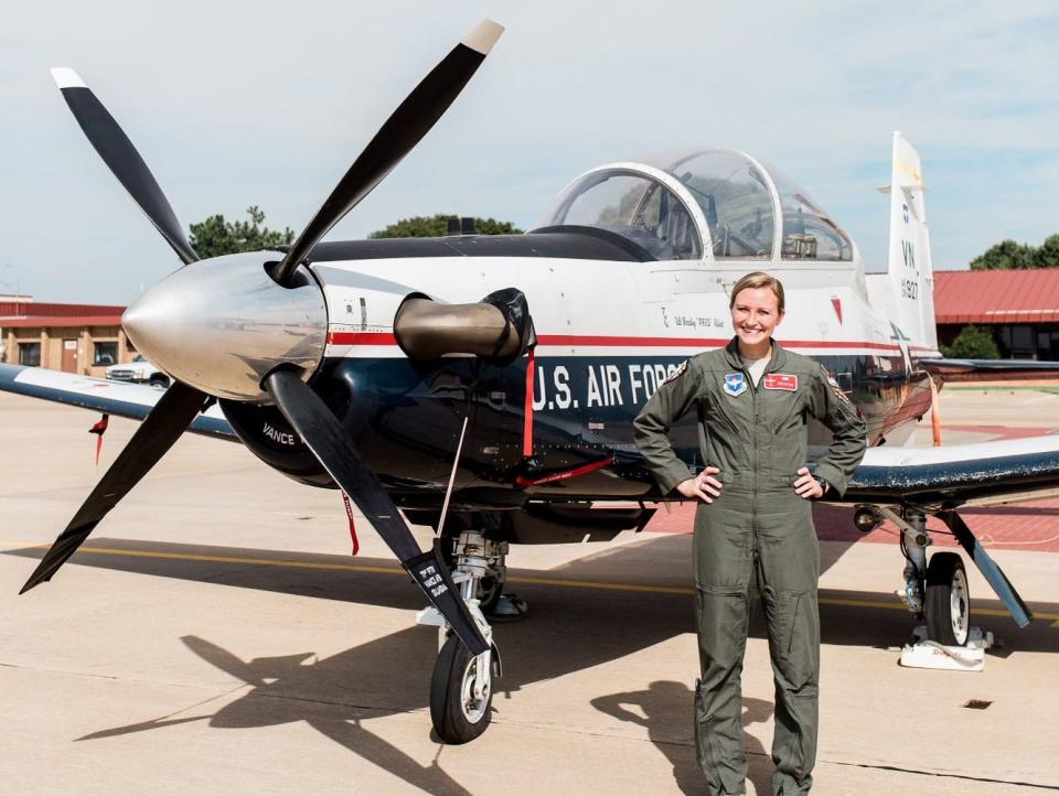 Taylor Bye standing next to a training aircraft