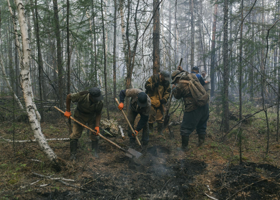 FILE - In this Sunday, July 18, 2021 file photo, volunteers and employees of the Yakutlesresurs dig a moat to stop a forest fire outside Magaras village 87 km. (61 miles) west of Yakustk, the capital of the republic of Sakha also known as Yakutia, Russia Far East. Each year, thousands of wildfires engulf wide swathes of Russia, destroying forests and shrouding broad territories in acrid smoke. This summer has seen particularly massive fires in Yakutia in northeastern Siberia following unprecedented heat. (AP Photo/Alexey Vasilyev, File)