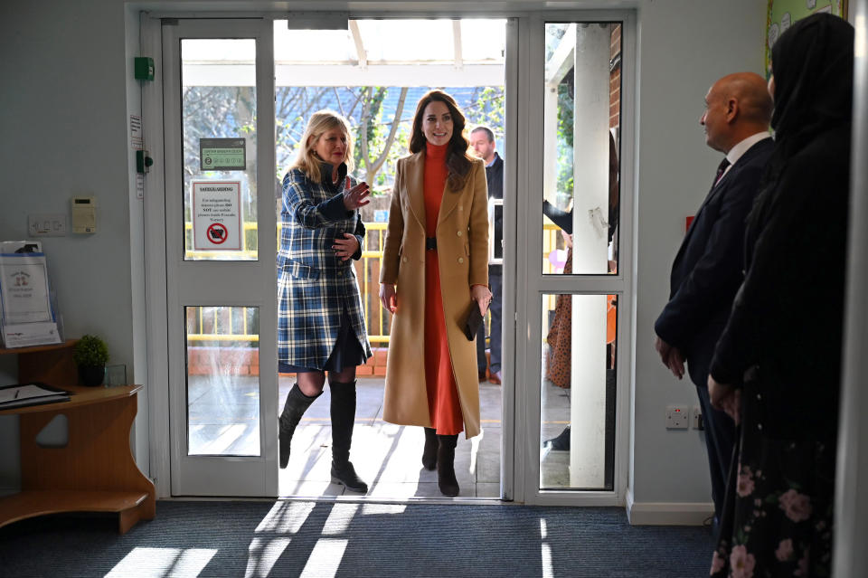 Prinzessin Kate trägt einen camelfarbenen Mantel mit einem Strickkleid in knalligem Orange (Bild: Justin Tallis - WPA Pool/Getty Images)