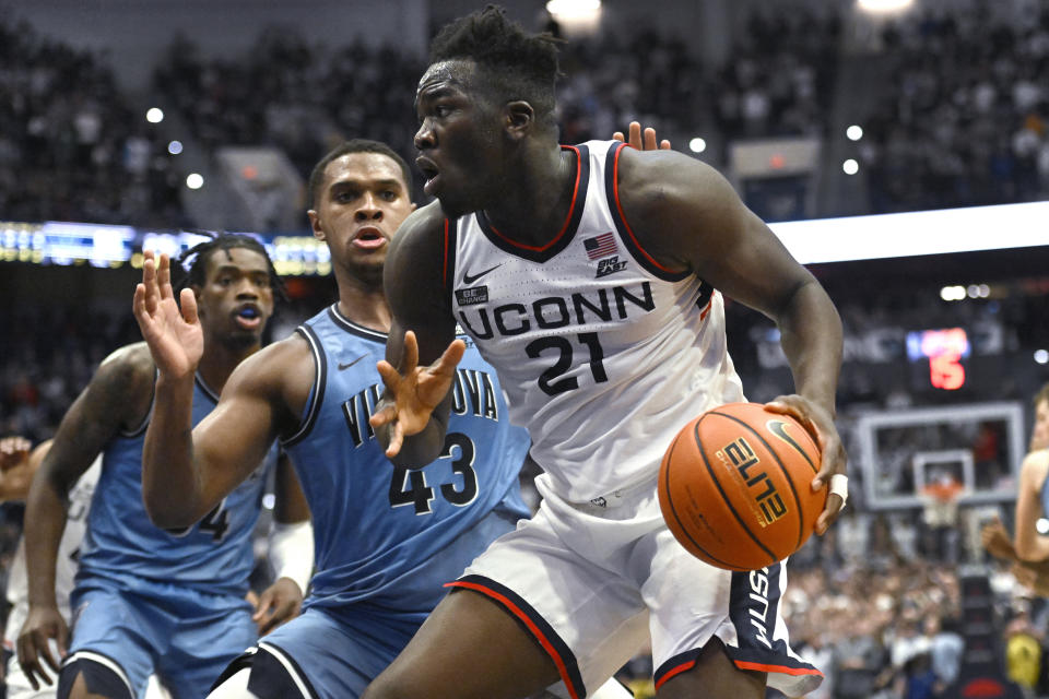 Connecticut's Adama Sanogo (21) drives to the basket as Villanova's Eric Dixon (43) defends during the second half of an NCAA college basketball game Wednesday, Dec. 28, 2022, in Hartford, Conn. (AP Photo/Jessica Hill)