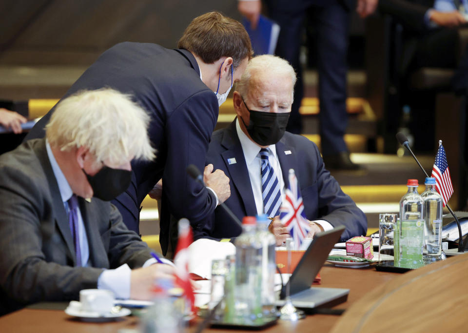 FILE - In this June 14, 2021, file photo French President Emmanuel Macron, center, speaks with U.S. President Joe Biden, right, during a plenary session at a NATO summit in Brussels. Ties between the United States and its oldest ally, France, have long been fraternal, but they've also been marked by deep French unease over their equality. French concerns about being the junior partner in the relationship boiled over last week when the U.S., Britain and Australia announced a new security initiative for the Indo-Pacific. (AP Photo/Olivier Matthys, Pool, File)