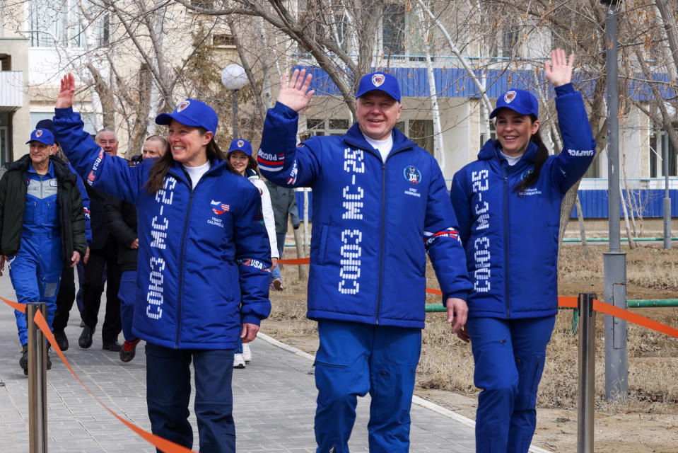 In this photo released by Roscosmos space corporation on Thursday, March 21, 2024 Roscosmos cosmonaut Oleg Novitsky, centre, Belarus' crew member Marina Vasilevskaya, right, and NASA astronaut Tracy Dyson, left, all members of the main crew to the International Space Station (ISS), wave to their relatives as they walk to a bus prior to the launch of a Soyuz-2.1a rocket at the Russian leased Baikonur cosmodrome, Kazakhstan. (Roscosmos space corporation via AP)