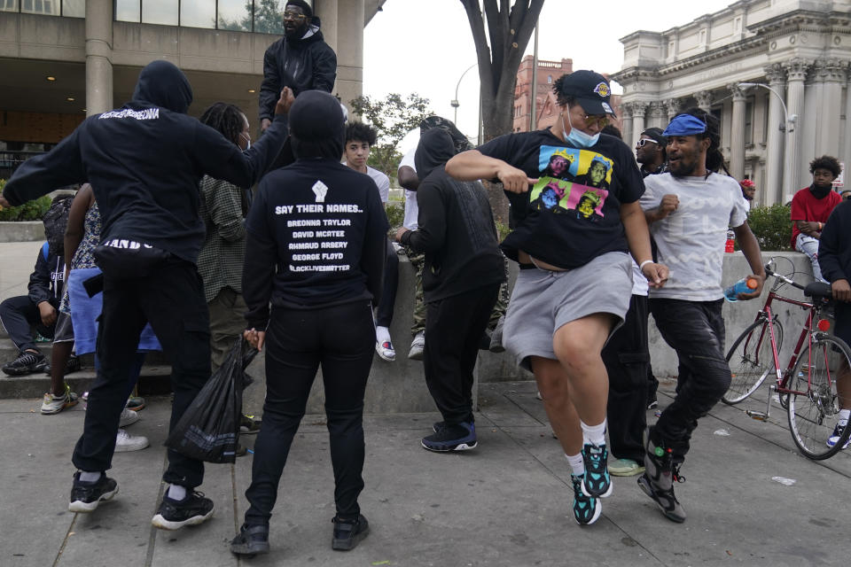 People dance in Jefferson square, Friday, Sept. 25, 2020, in Louisville. Breonna Taylor's family demanded Friday that Kentucky authorities release all body camera footage, police files and the transcripts of the grand jury hearings that led to no charges against police officers who killed the Black woman during a March drug raid at her apartment. (AP Photo/Darron Cummings)