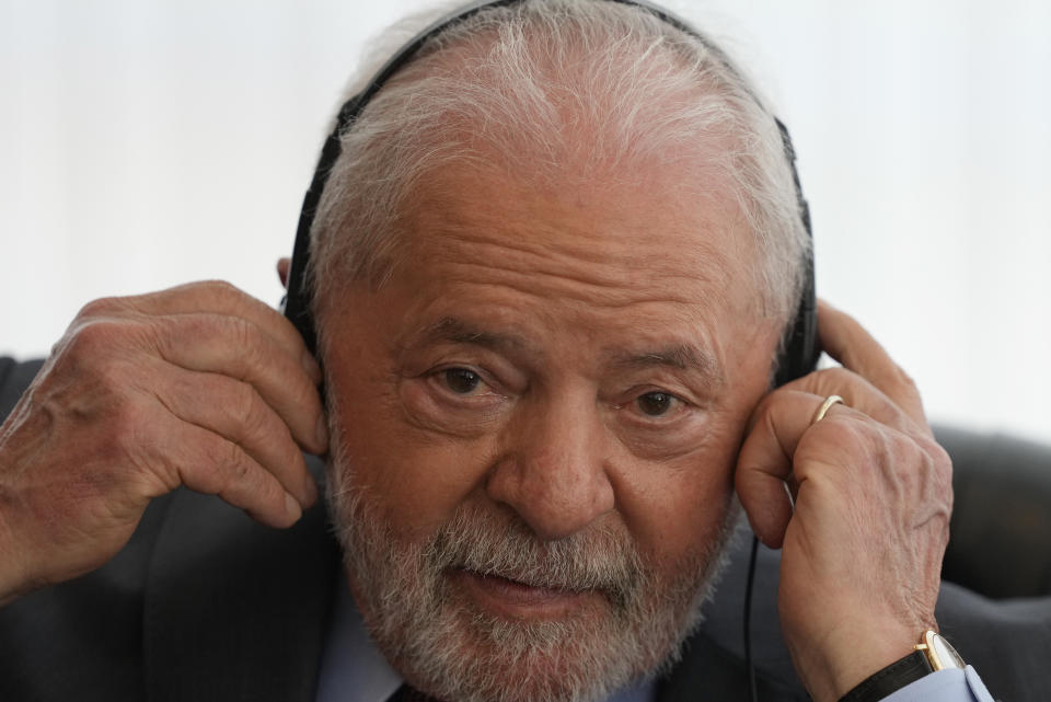 Brazil's President Luiz Inacio Lula da Silva puts on earphones for translation for a bilateral meeting with Spain's King Felipe VI at Itamaraty Palace the day after Lula's inauguration in Brasilia, Brazil, Monday, Jan. 2, 2023. (AP Photo/Eraldo Peres)