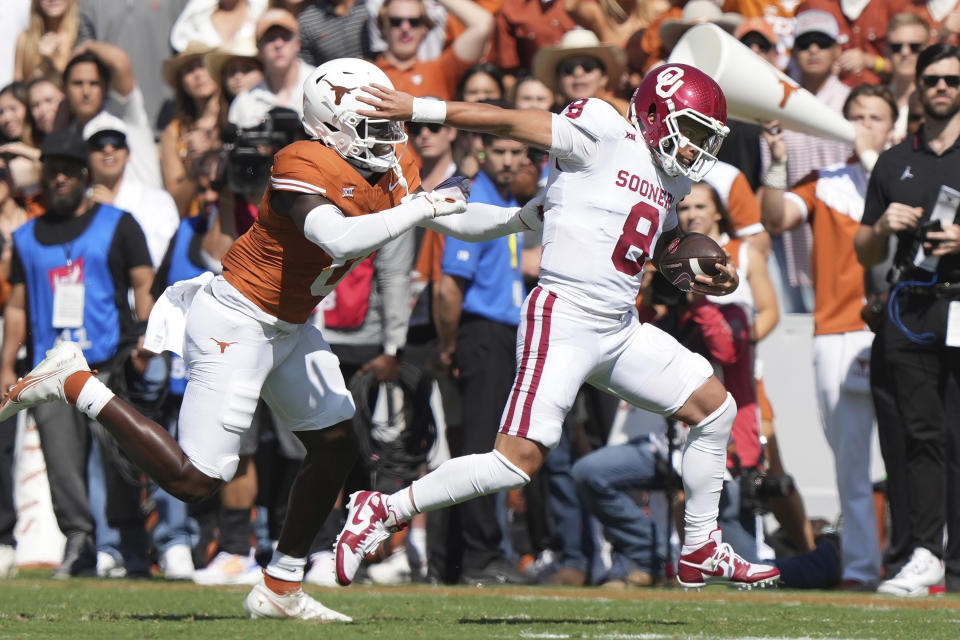 Oklahoma quarterback Dillon Gabriel (8) runs ahead of Texas linebacker Anthony Hill Jr. (0) during the first half of an NCAA college football game at the Cotton Bowl in Dallas, Saturday, Oct. 7, 2023. (AP Photo/LM Otero)