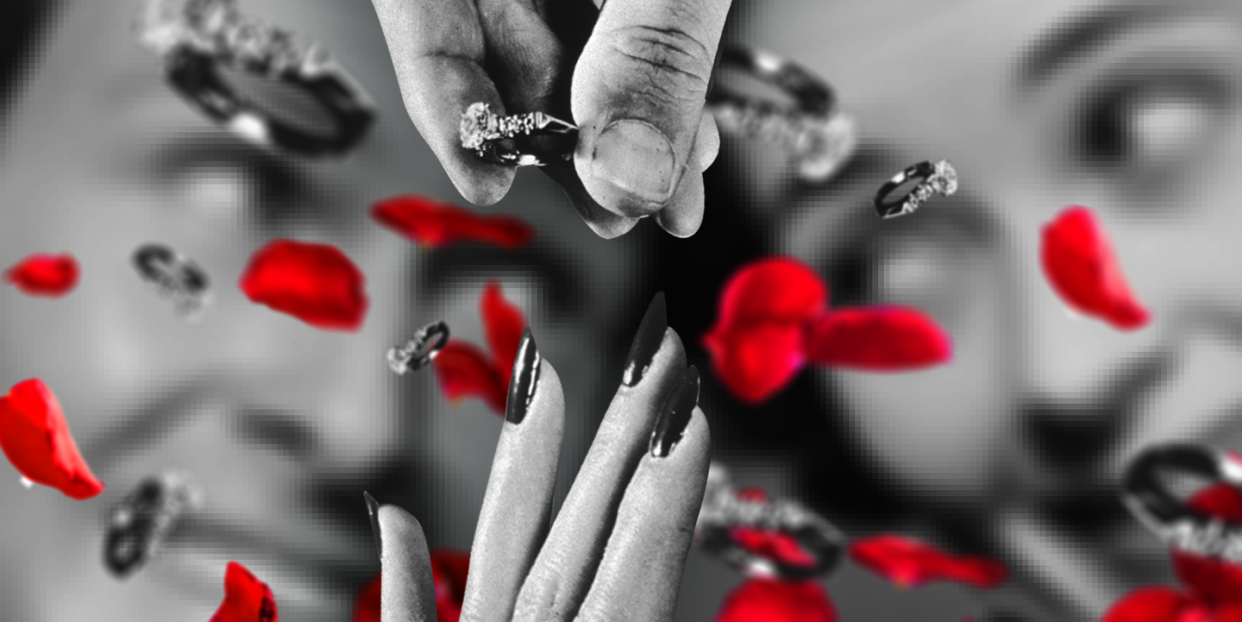 a black and white image of engagement rings floating towards a hand with a couple in the background and red rose petals