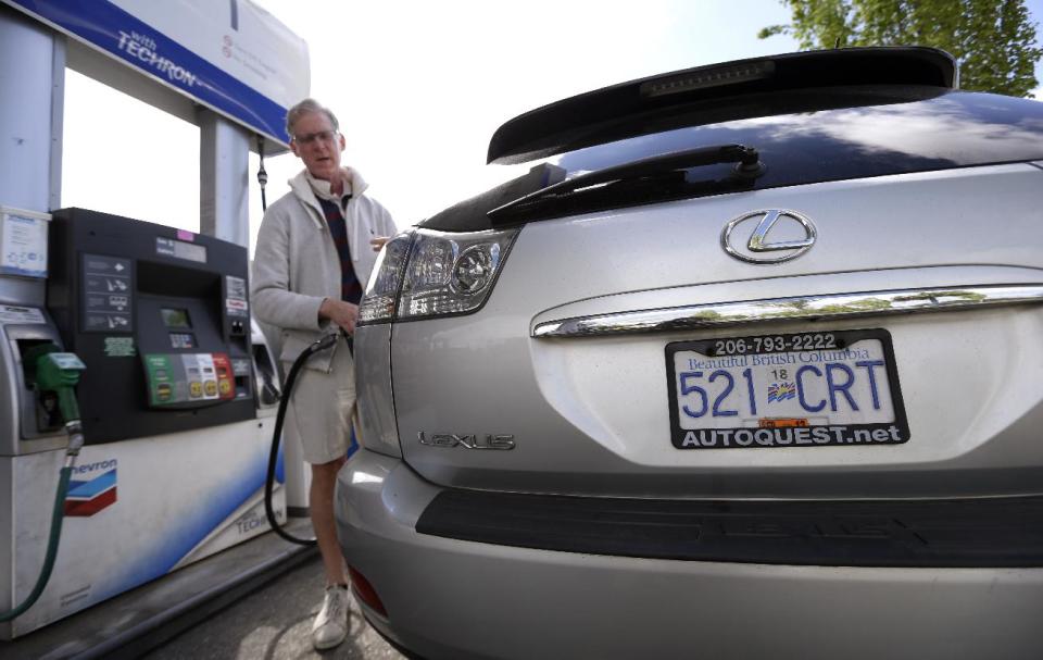 In this Thursday, May 23, 2013 photo, Curt Griffiths, from nearby White Rock, British Columbia, pumps gas at a station in Blaine, Wash. In April 2013, in its 2014 fiscal year budget proposal, the Department of Homeland Security requested permission to study a fee at the nation's land border crossings. The request has sparked wide opposition among members of Congress from northern states, who vowed to stop it. A fee, they say, would hurt communities on the border that rely on people, goods and money moving between the U.S. and Canada. (AP Photo/Elaine Thompson)