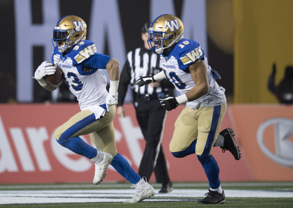 Winnipeg Blue Bombers' Andrew Harris, left, celebrates his touchdown against the Hamilton Tiger Cats with teammate Nic Demski during the first half of a CFL football game in the 107th Grey Cup in Calgary, Alberta, Sunday, Nov. 24, 2019. (Frank Gunn/The Canadian Press via AP)