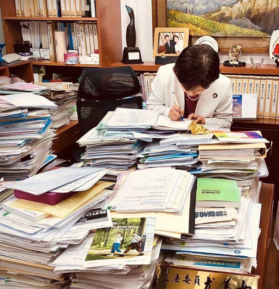 尤美女臉書貼出她平時伏案在國會辦公室的照片，桌上堆疊著滿滿待審核的文件。（翻攝自尤美女臉書）