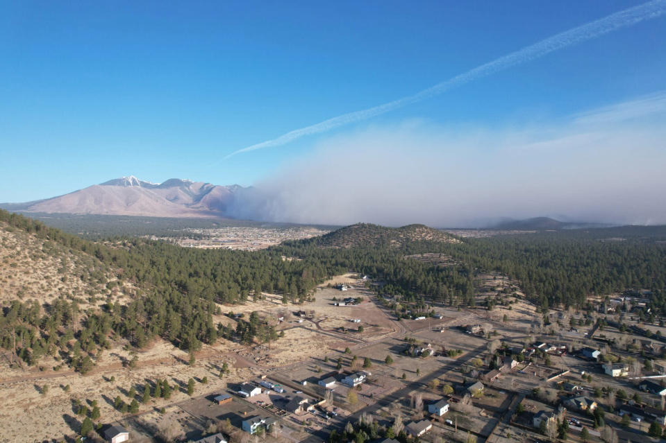 This Twitter photo provided by Zak Pressley shows a wildfire burning in Doney Park in Coconino County, Ariz., on Tuesday, April 19, 2022. An Arizona wildfire doubled in size overnight into Wednesday, a day after heavy winds kicked up a towering wall of flames outside a northern Arizona tourist and college town, ripping through two dozen structures and sending residents of more than 700 homes scrambling to flee. (Zak Pressley via AP)