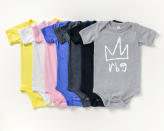 This image shows a variety of onesies with a line drawing of a crown and the initials “rbg” in lowercase lettering. Twenty percent of proceeds will be donated to the ACLU's Women's Rights Project. (Lizzy Russinko via AP)