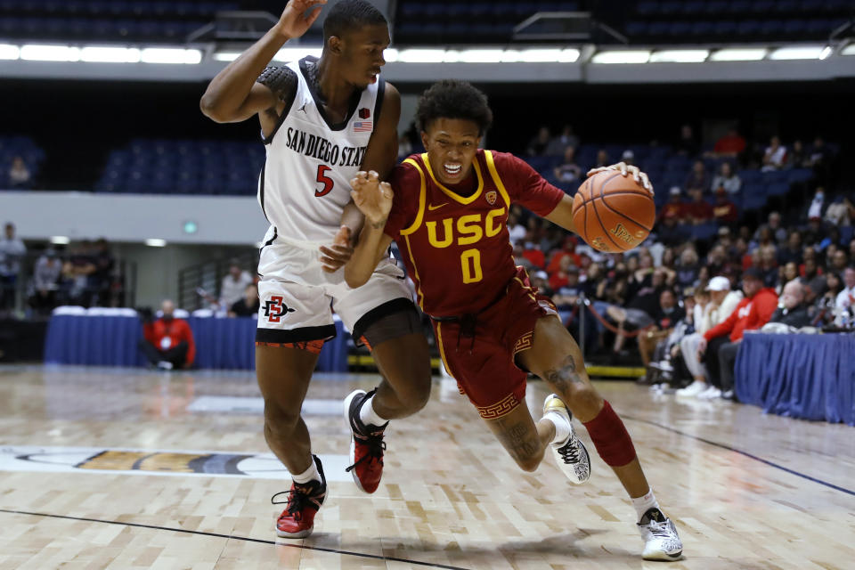 Southern California guard Boogie Ellis, right, drives past San Diego State guard Lamont Butler during the first half of an NCAA college basketball game at the Wooden Legacy tournament in Anaheim, Calif., Friday, Nov. 26, 2021. (AP Photo/Alex Gallardo)