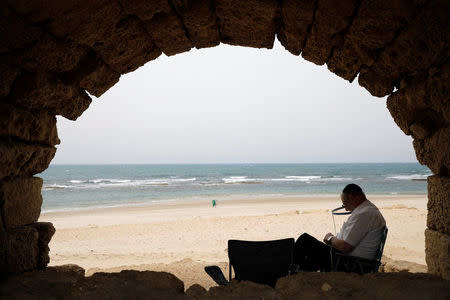 A visitor sits under the queduct in the Old city of Caesarea, Israel April 26, 2017. REUTERS/Amir Cohen