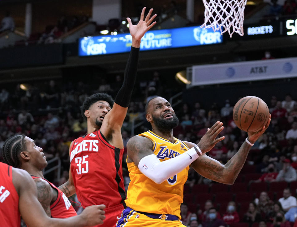 Los Angeles Lakers forward LeBron James, right, shoots as Houston Rockets center Christian Wood (35) defends during the first half of an NBA basketball game Tuesday, Dec. 28, 2021, in Houston. (AP Photo/Eric Christian Smith)