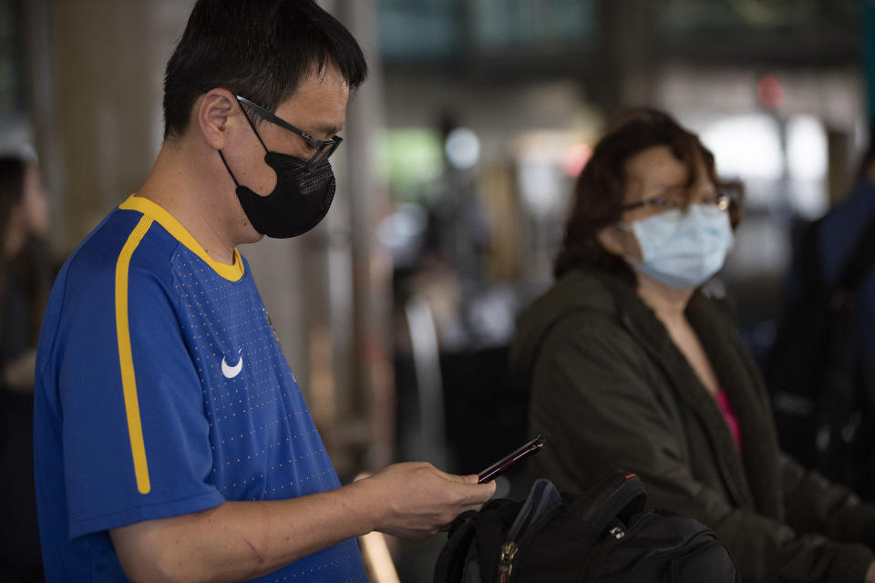 Passengers wearing masks as a precaution against the spread of the new coronavirus COVID-19 arrive to the Sao Paulo International Airport in Sao Paulo, Brazil, Wednesday, Feb. 26, 2020. (AP Photo/Andre Penner)